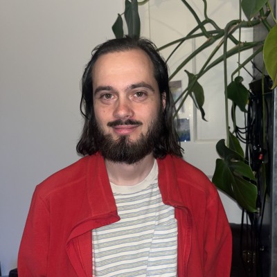Ein Mann mit Bart schaut frontal in die Kamera.
