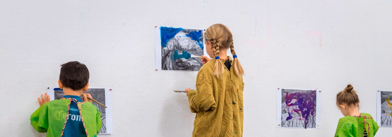 Drei Kinder malen an einer Wand im Atelier des Aargauer Kunsthauses.