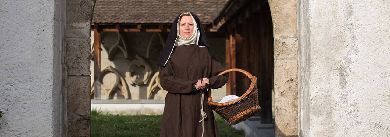 Eine Klosterfrau steht in einem Tor
