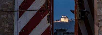 Blick durch ein Fenster auf Schloss Wildegg bei Nacht