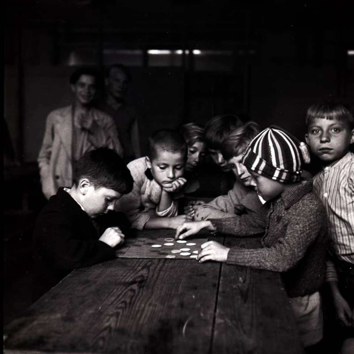 Eine Gruppe von Kindern sitzt an einem Tisch in einem Interniertenlager in Adliswil. 