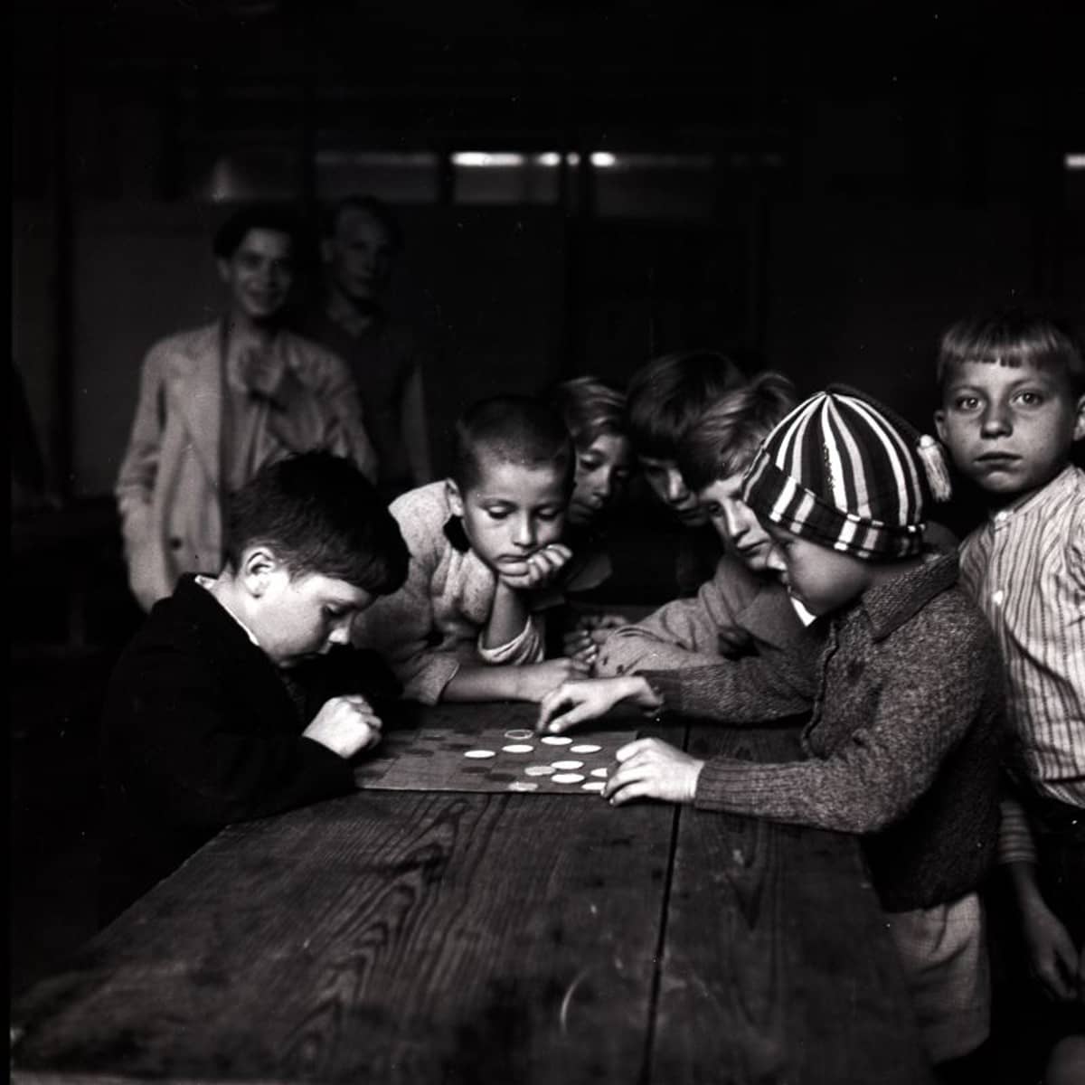 Eine Gruppe von Kindern sitzt an einem Tisch in einem Interniertenlager in Adliswil.