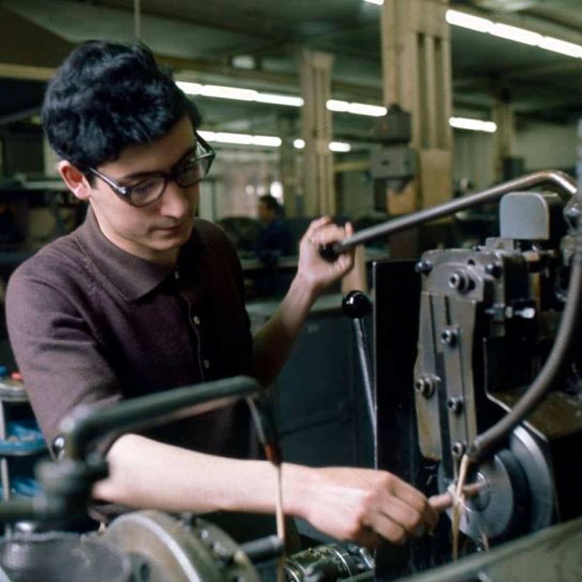 Ein italienischer Fremdarbeiter bedient eine Maschine in einer Fabrik in Baden.