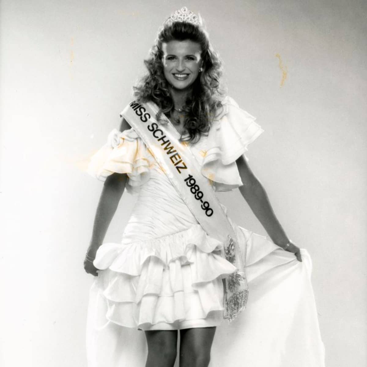 Catherine Mesot, Miss Schweiz 1989 posiert mit Krone und Schärpe. 