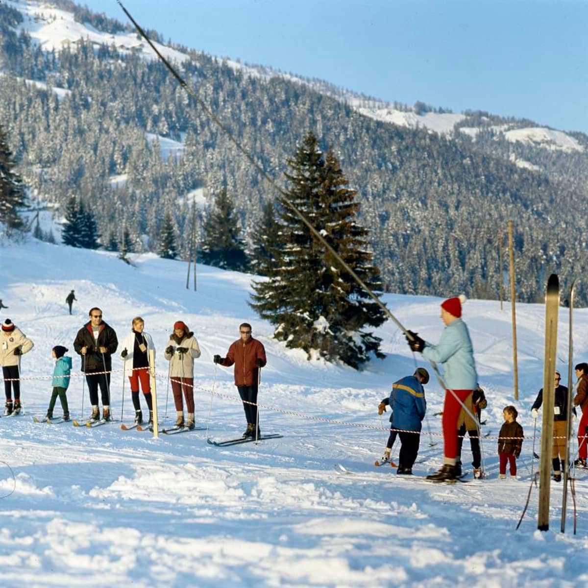 Junger Skifahrer am Bugellift, im Hitnergrund eine Schlange mit wartenden Skifahrer