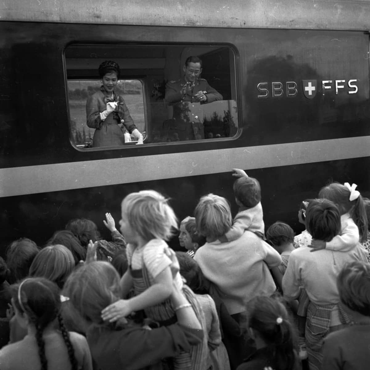 Königspaar winkt aus dem Zugfenster, Menschenmasse auf dem Bahnsteig