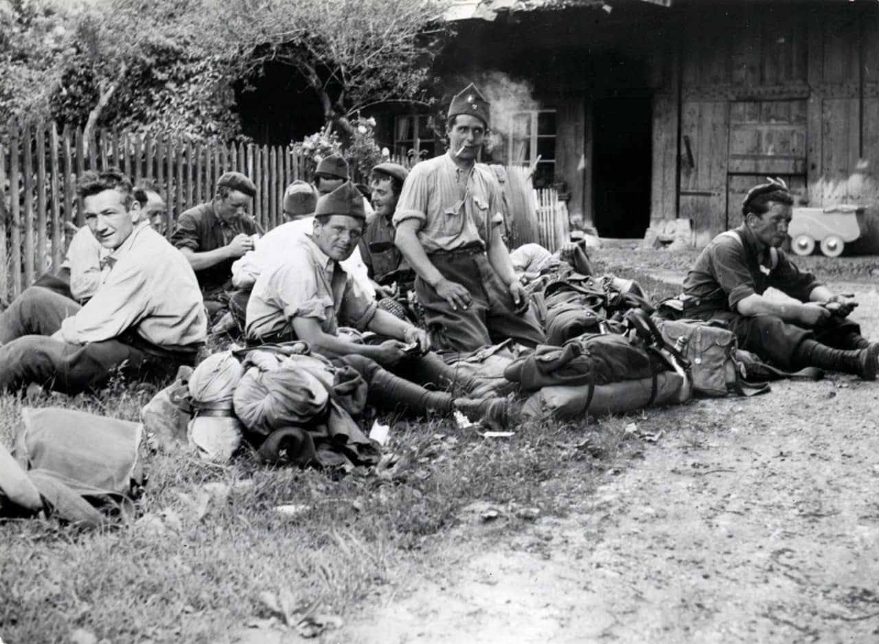 Eine Gruppe von internierten italienischen Soldaten, sitzend. 