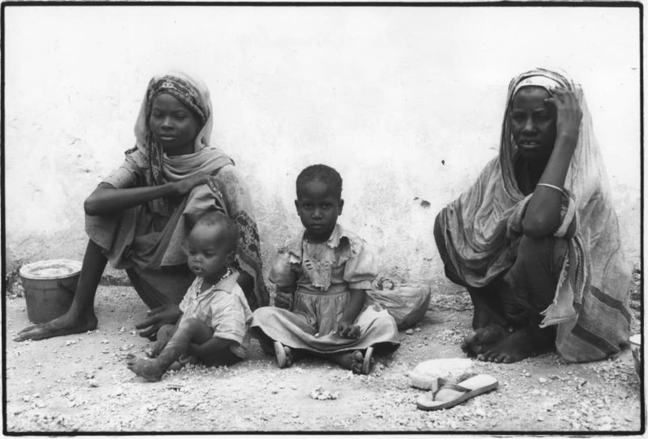 Zwei somalische Frauen und zwei Kleinkinder sitzen am Boden.