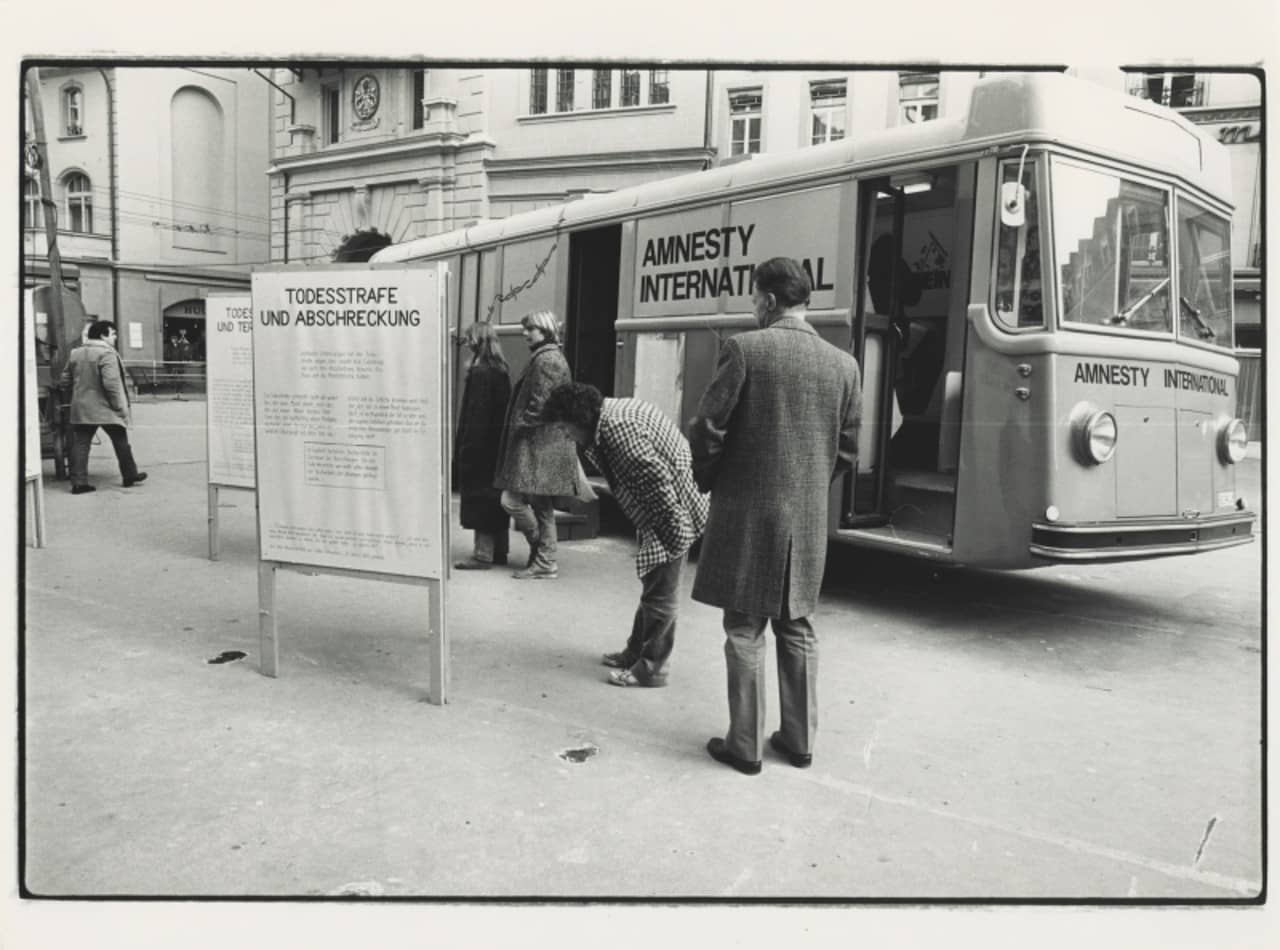 Passanten lesen die Plakate der Amnesty International Ausstellung zum Thema Todesstrafe. Die Ausstellung reiste 1981 in einem Bus durch die Schweiz.