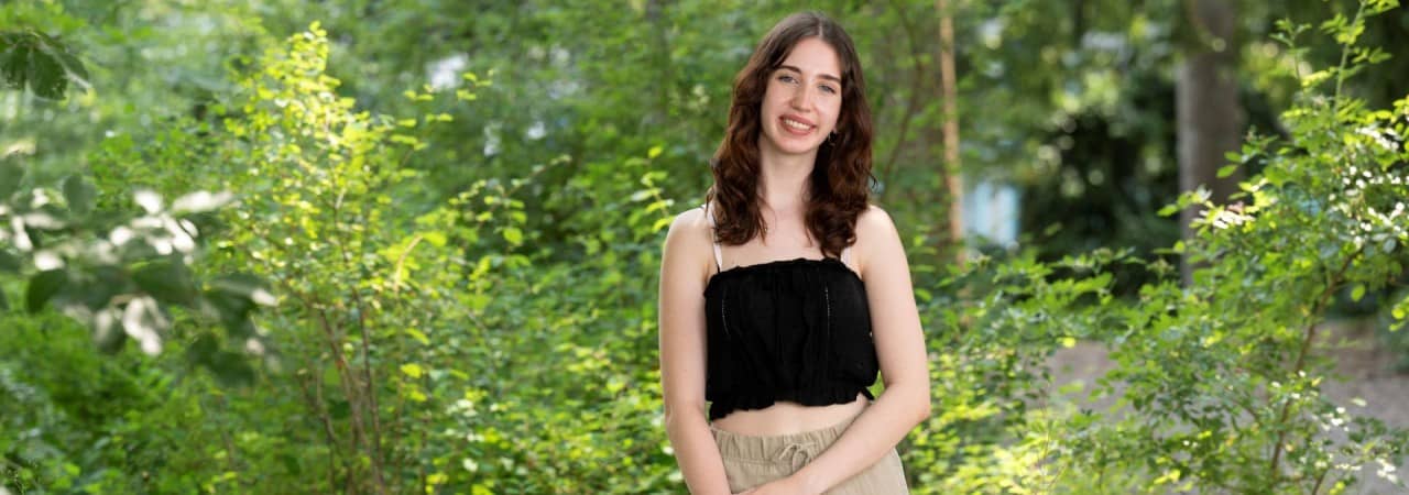 Mädchen steht in Sträuchern