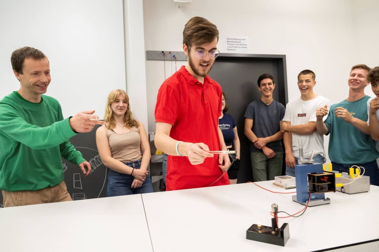 Schülerin und Schüler beim Physik Experiment.