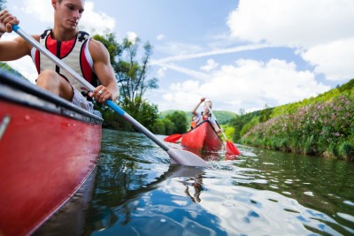Eine Kanugruppe ist auf dem Fluss unterwegs.