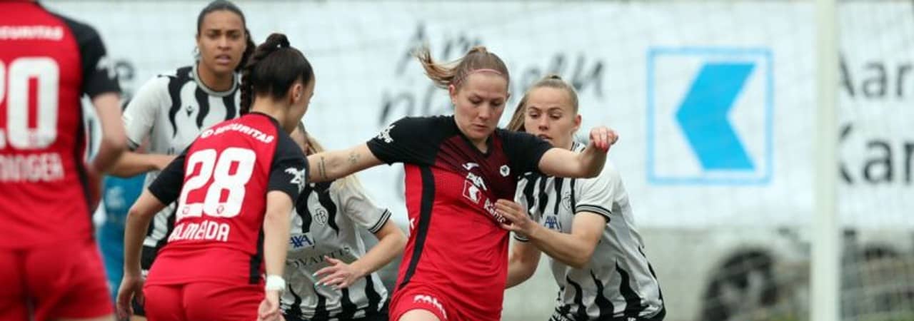 Eine Frauenfussballmannschaft ist am Fussball spielen.