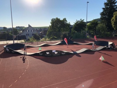 Kinder und Jugendliche fahren auf einem mobilen Pumptrack.