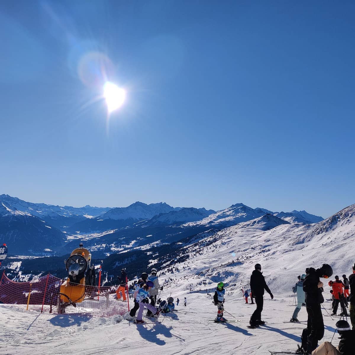 Personen auf der Skipiste bei wundervollem Wetter.