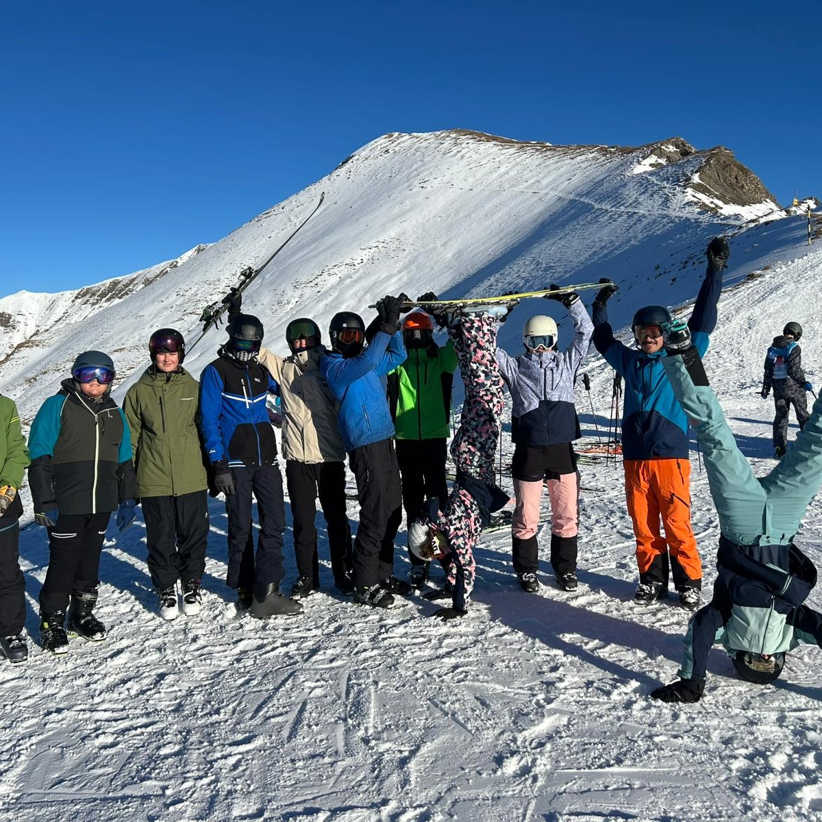 Elf Personen posieren im Schnee.