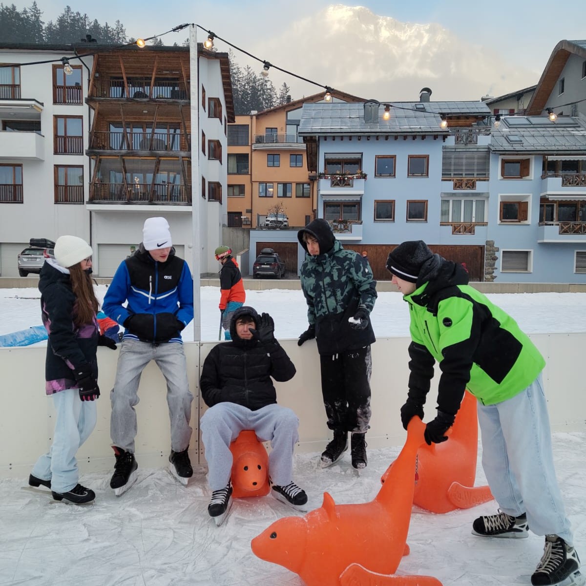Mehrere Jugendliche sind auf der Eisbahn am Schlittschuh fahren.