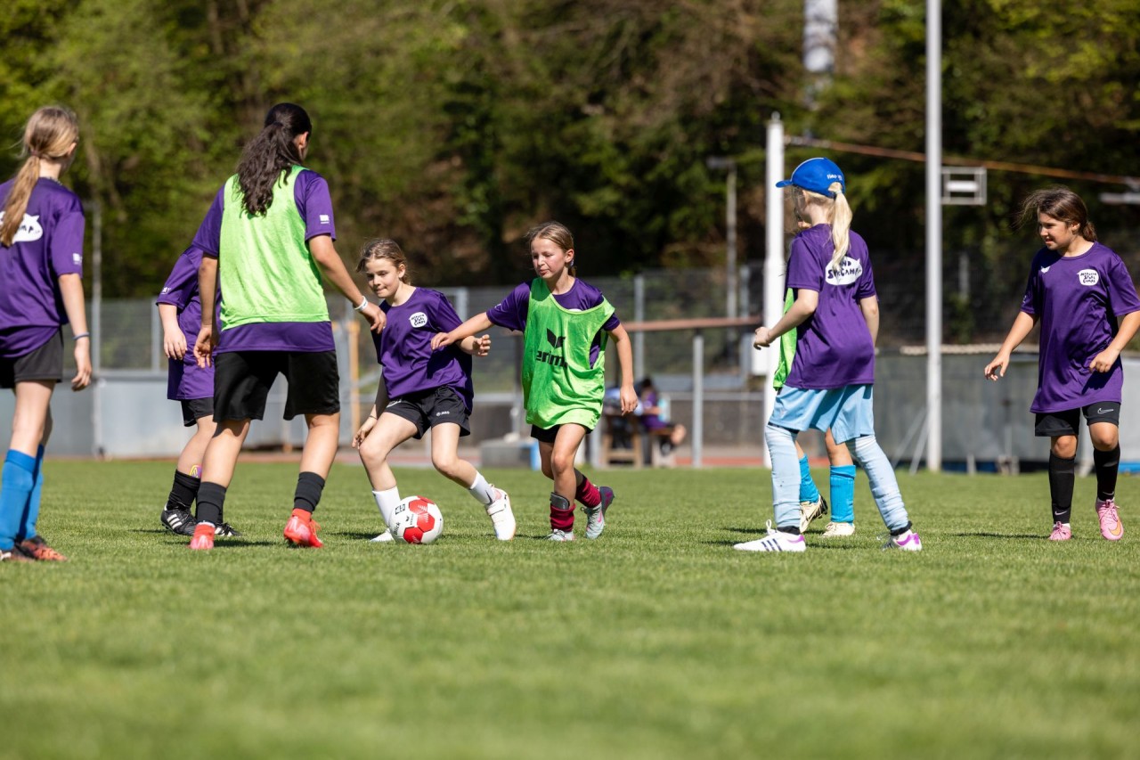 Junge Mädchen spielen Fussball auf dem Fussballfeld.