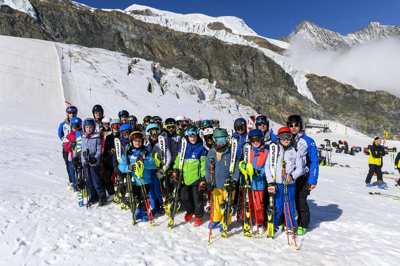 Gruppenfoto mit Skifahrerinnen und Skifahrern auf der Piste