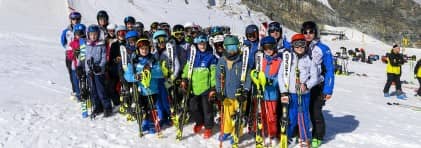 Gruppenfoto mit Skifahrerinnen und Skifahrer auf der Piste