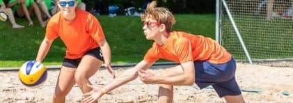 zwei Jugendliche spielen Beachvolleyball