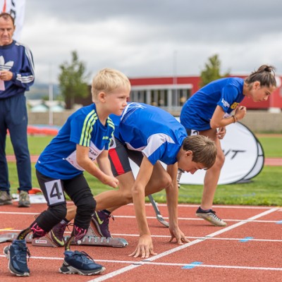 Jugendliche mit einer Beeinträchtigung stehen an der Startlinie im Leichtathletik.