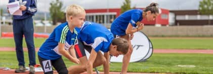 Jugendliche mit einer Beeinträchtigung stehen an der Startlinie im Leichtathletik.