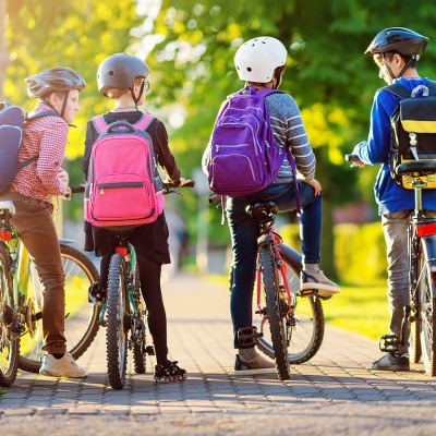 Vier Jugendliche warten mit ihren Fahrrädern.