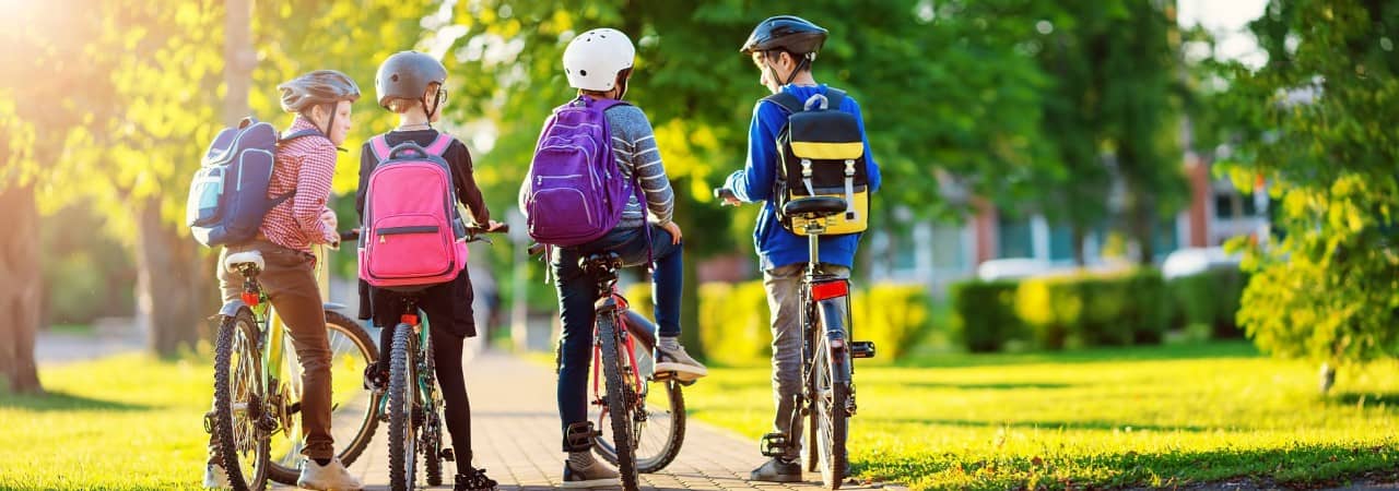 Vier Jugendliche warten mit ihren Fahrrädern.