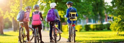 Vier Jugendliche warten mit ihren Fahrrädern.