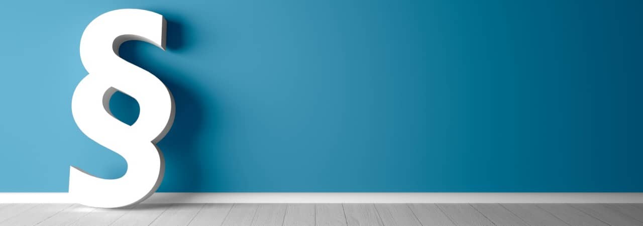 Weisses Paragraphenzeichen lehnt an blauer Wand