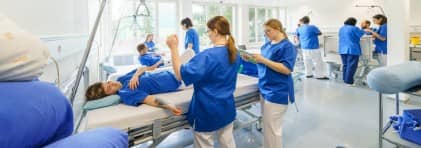 Pflegende in Ausbildung üben an ihren Mitstudierenden tägliche Arbeiten vom Gesundheitspersonal.