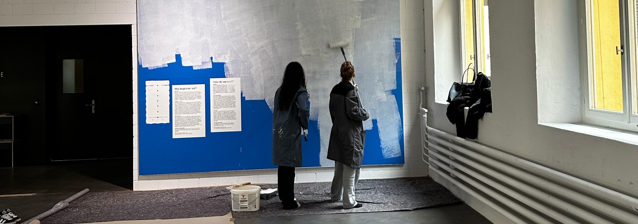 Schülerinnen bemalen eine Leinwand.