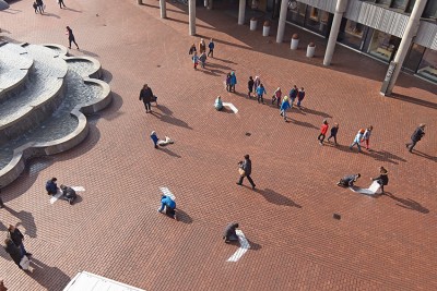 Sicht von oben auf Jugendliche, die weisse Pfeile auf den Neumarktplatz in Brugg malen.