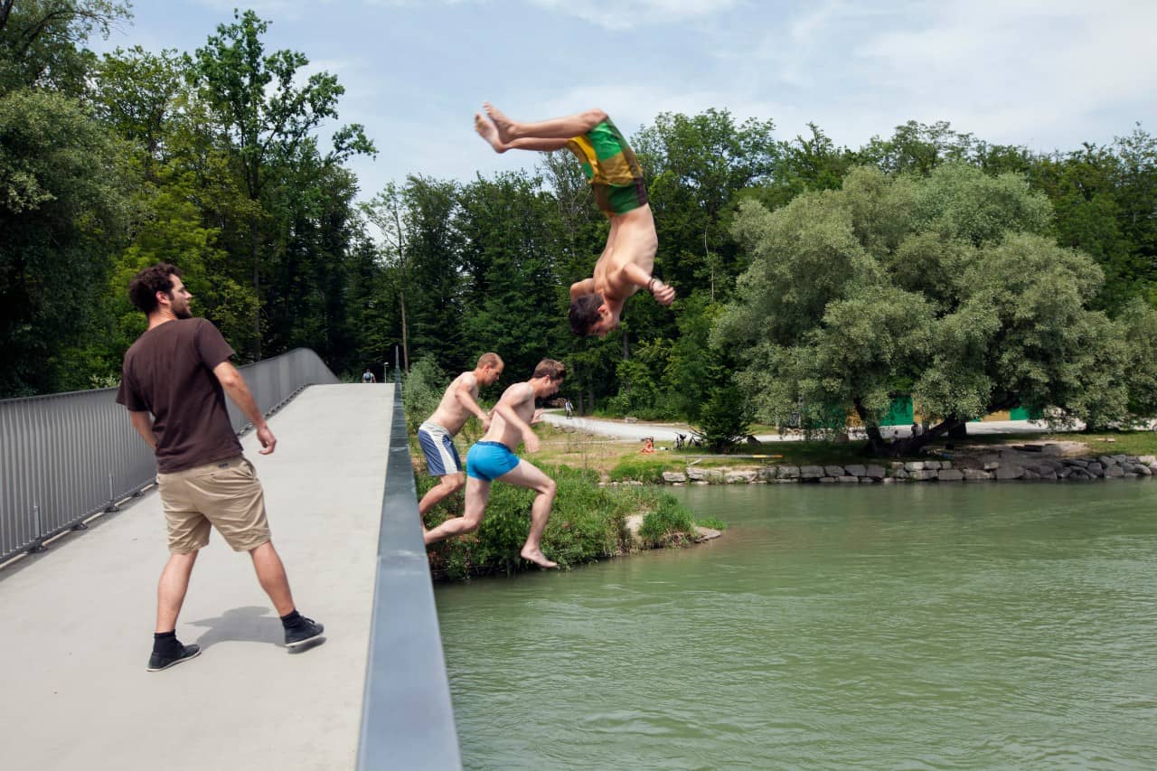 Jugendliche springen vom Aaresteg in den Fluss.