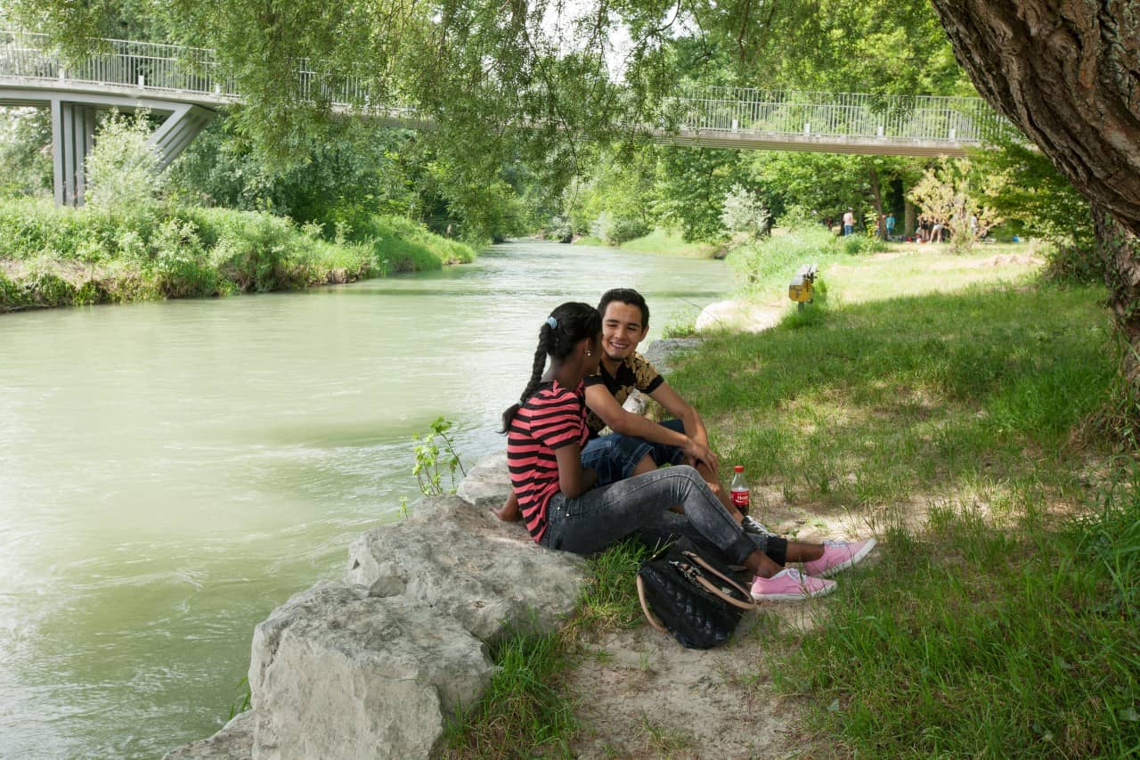 Zwei Personen sitzen auf Natursteineelementen am Aareufer in Brugg.