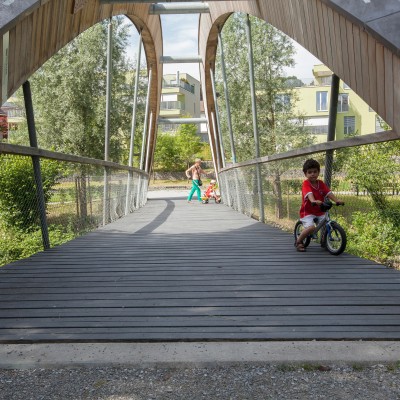 Ein junger Velofahrer fährt über die neue Brücke zum Park Bünzhalde in Dottikon.