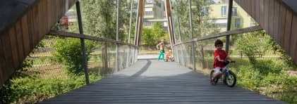 Ein junger Velofahrer fährt über die neue Brücke zum Park Bünzhalde in Dottikon.
