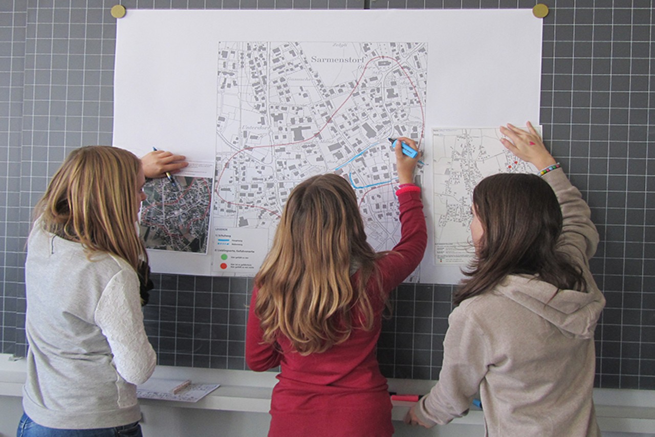 Schüler zeichnen ihren Schulweg auf einen grossen Plan
