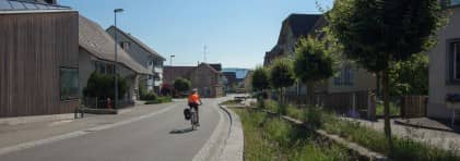Eine Velofahrerin fährt auf der neu gestalteten Dorfstrasse in Spreitenbach.