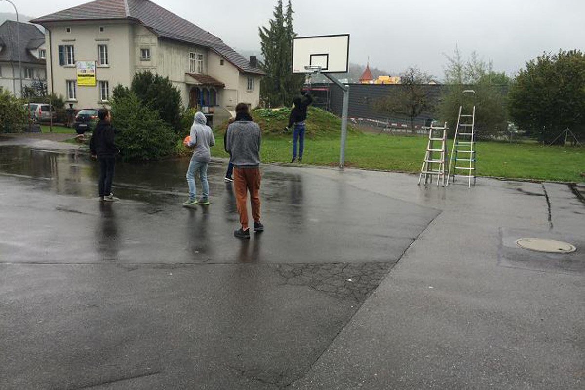 Einige Schüler probieren den neuen Basketballkorb gleich aus