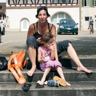 Eine Mutter mit ihrer Tochter sitzen auf einer Treppe in der Zofinger Altstadt.