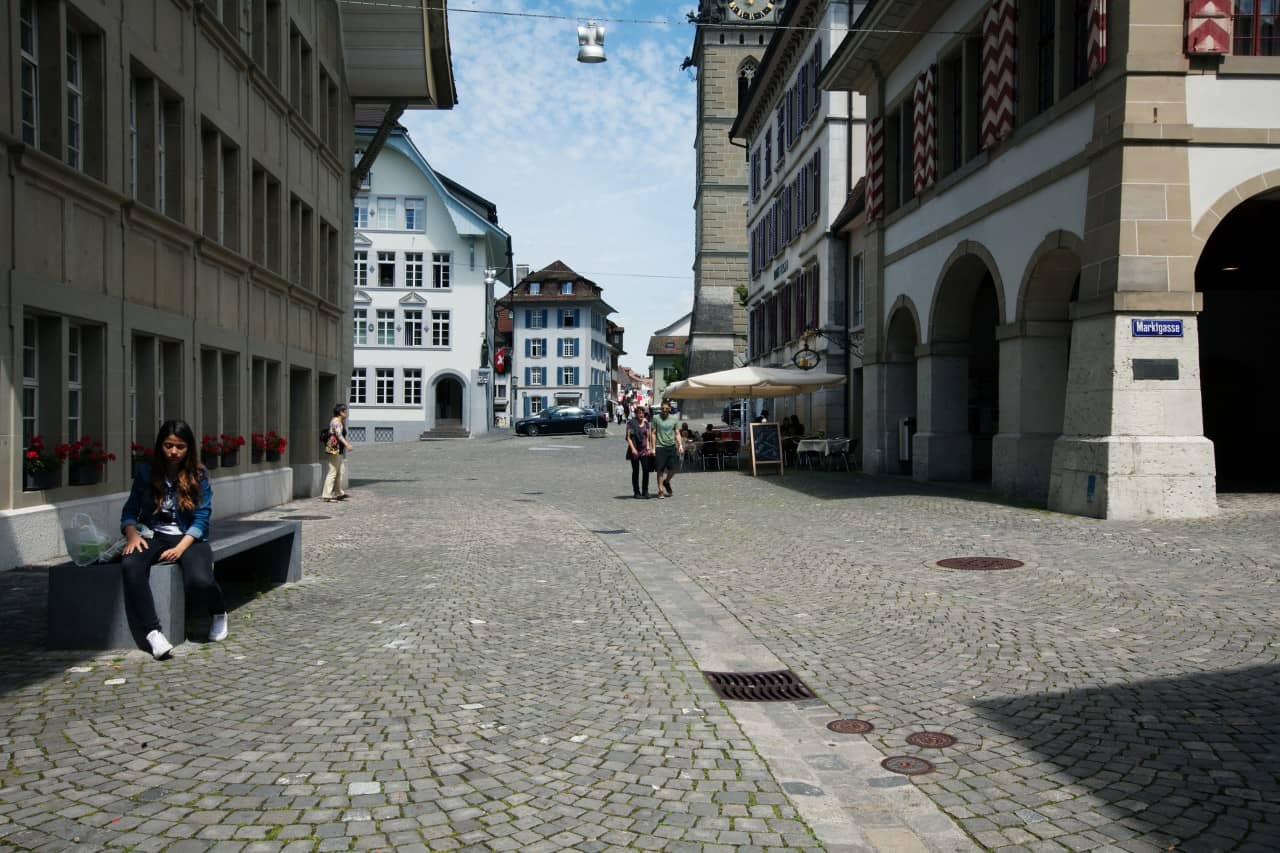 Menschen verweilen und spazieren auf der Marktgasse in der Zofinger Altstadt.