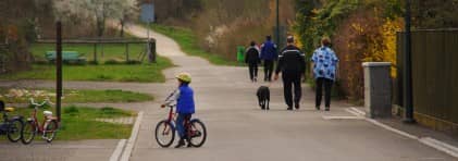 Foto von spazierenden Personen und einem Kind mit Fahrrad auf dem Gönhardweg in Suhr.