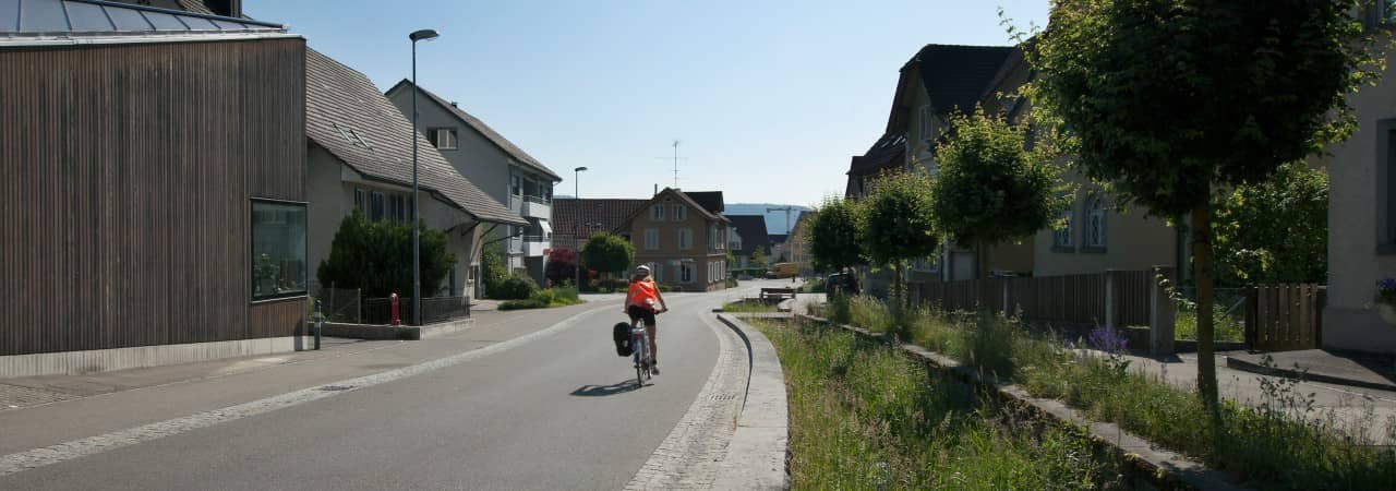 Foto einer Velofahrerin auf der sanierten Dorfstrasse in Spreitenbach.