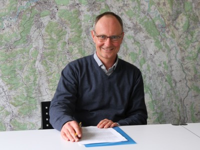 Portrait des Abteilungsleiters Daniel Kolb vor dem Richtplan als Karte des Kantons Aargau.