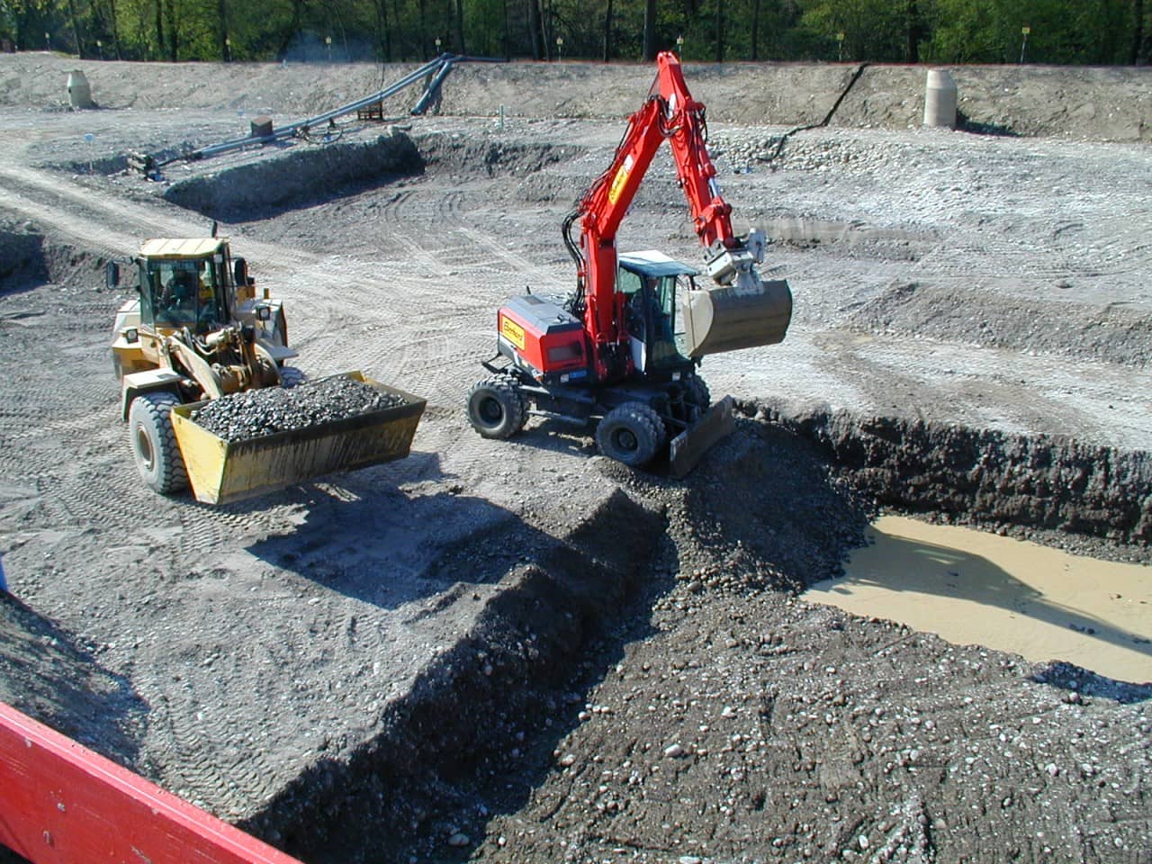 Bagger und Radlader beim Aushub bis ins Grundwasser