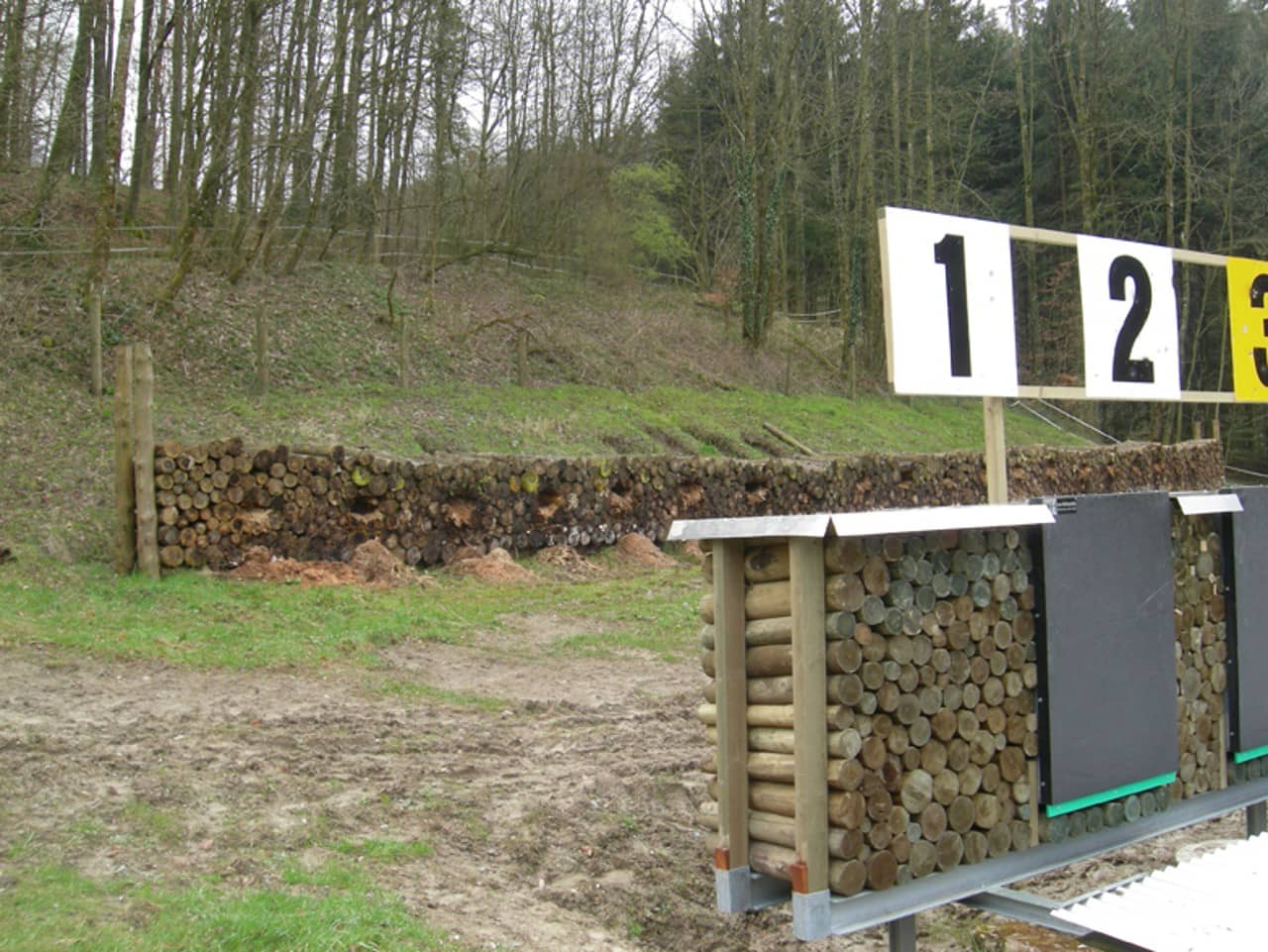 Geschichtete Holzbeigen im Bereich hinter den Schiessscheiben fungieren als Kugelfang.