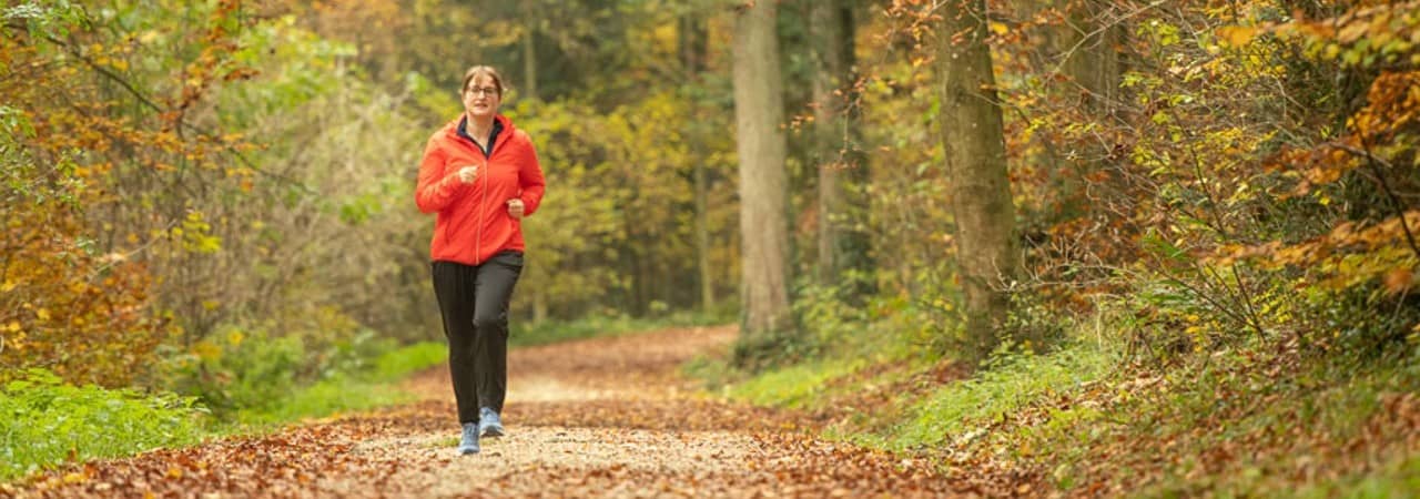Eine Joggerin auf einem Waldweg