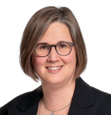 Andrea R. Plüss, Leiterin Statistik Aargau, lächelnd, in schwarzem Jacket und weisser Bluse und schwarzer Brille.